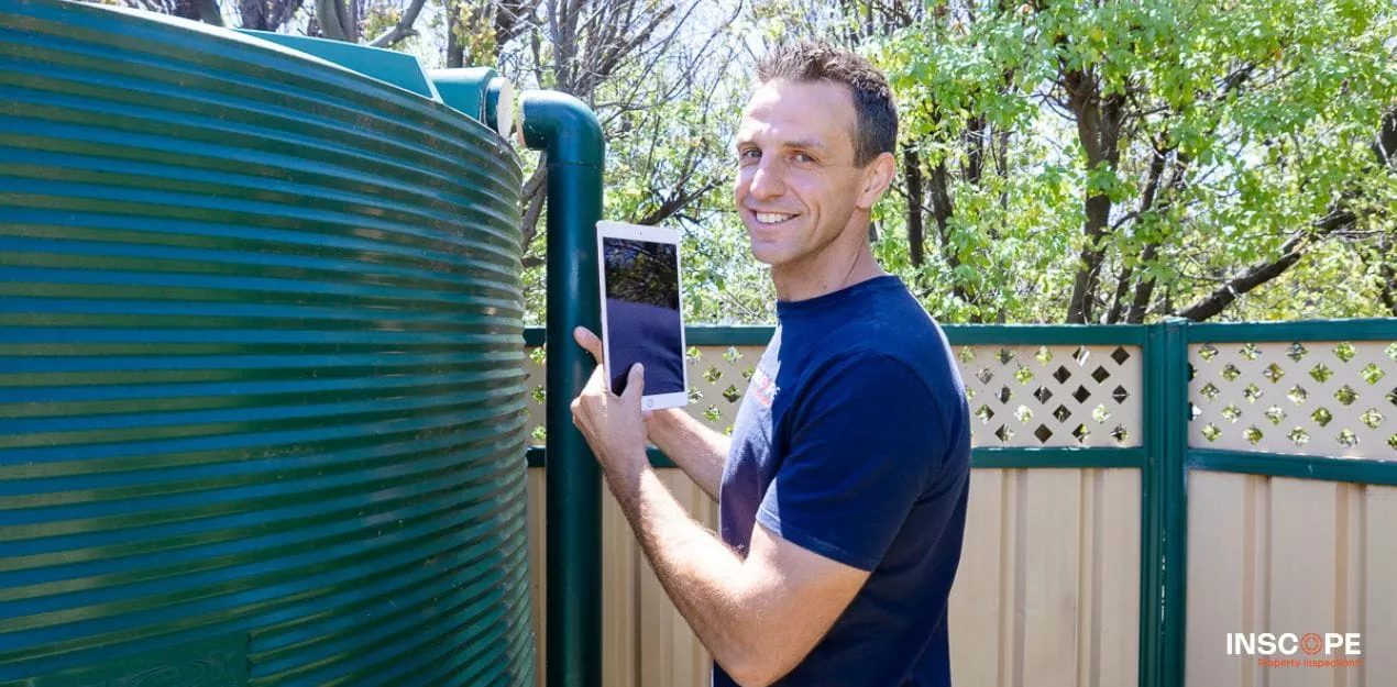 Building inspector conducting an exterior roof inspection on a Melbourne residential property.